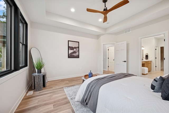 3909 54th St, Edina, MN 55424 - bedroom with a tray ceiling, light wood-style floors, recessed lighting, connected bathroom, and a ceiling fan