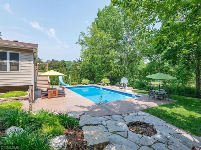 20108 Calgary Trl, Empire Twp, MN 55024 - outdoor pool with a water slide, an outdoor fire pit, a patio, and a yard