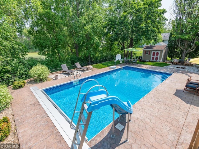 20108 Calgary Trl, Empire Twp, MN 55024 - swimming pool with a storage unit, a patio, and view of scattered trees