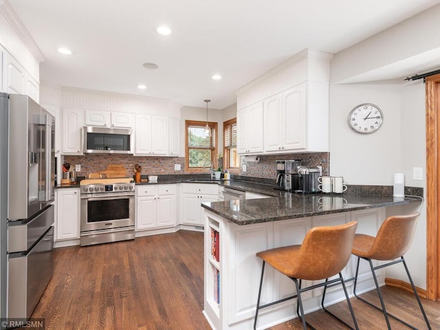 20108 Calgary Trl, Empire Twp, MN 55024 - kitchen featuring stainless steel appliances, a peninsula, tasteful backsplash, white cabinetry, and recessed lighting