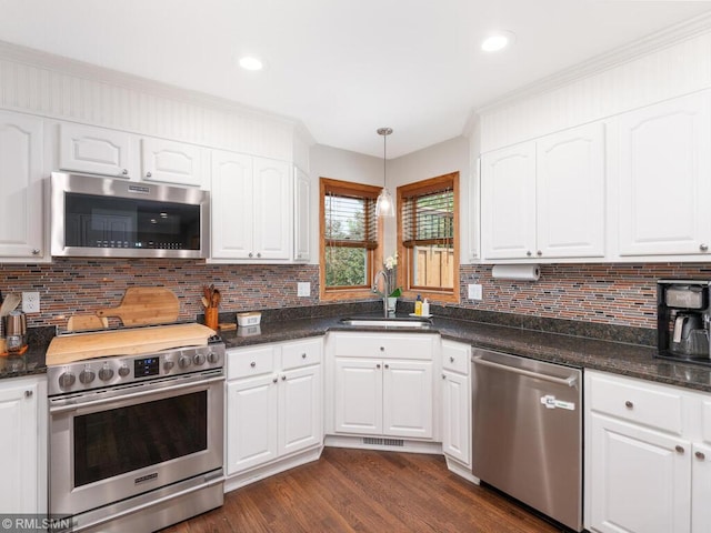 20108 Calgary Trl, Empire Twp, MN 55024 - kitchen with stainless steel appliances, white cabinetry, dark wood finished floors, tasteful backsplash, and recessed lighting
