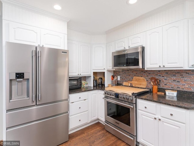 20108 Calgary Trl, Empire Twp, MN 55024 - kitchen with stainless steel appliances, white cabinetry, dark stone counters, dark wood finished floors, and decorative backsplash