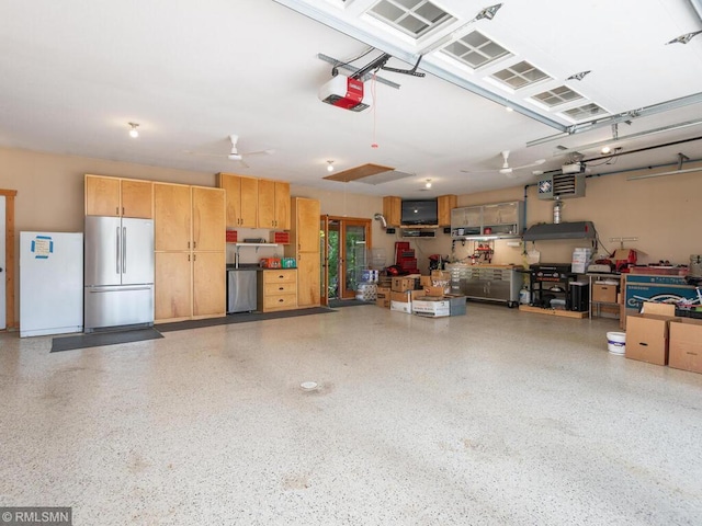 20108 Calgary Trl, Empire Twp, MN 55024 - garage with stainless steel fridge, a garage door opener, a workshop area, freestanding refrigerator, and fridge