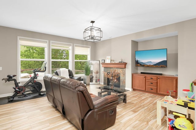 11950 75th St NE, Otsego, MN 55301 - living area featuring light wood-style flooring, a chandelier, and a tiled fireplace