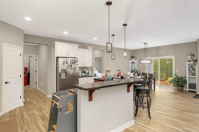 11950 75th St NE, Otsego, MN 55301 - kitchen featuring stainless steel refrigerator with ice dispenser, a kitchen bar, light wood-style flooring, white cabinetry, and recessed lighting