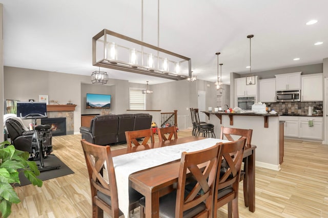 11950 75th St NE, Otsego, MN 55301 - dining room featuring a warm lit fireplace, light wood-type flooring, and recessed lighting