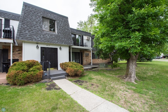 2417 Demores Dr S Unit 2, Fargo, ND 58103 - view of front facade with mansard roof, a balcony, roof with shingles, a front yard, and stucco siding