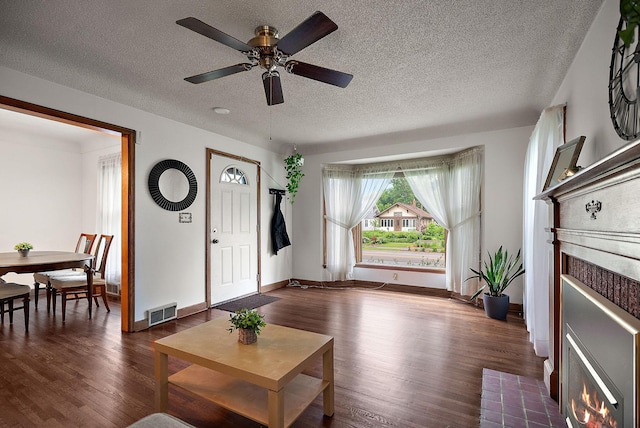 1442 Como Ave, Saint Paul, MN 55108 - living room featuring wood finished floors, a ceiling fan, a fireplace with flush hearth, and a textured ceiling