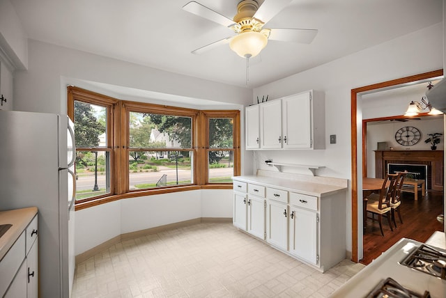 1442 Como Ave, Saint Paul, MN 55108 - kitchen with freestanding refrigerator, light countertops, white cabinetry, and a ceiling fan