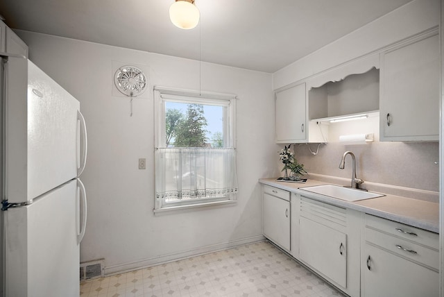 1442 Como Ave, Saint Paul, MN 55108 - kitchen featuring freestanding refrigerator, light flooring, light countertops, and white cabinets