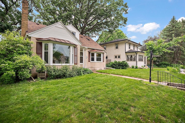 1442 Como Ave, Saint Paul, MN 55108 - view of front of home featuring a front yard, a chimney, and stucco siding