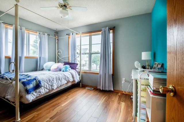 5724 4th St NE, Fridley, MN 55432 - bedroom with multiple windows, wood finished floors, and a ceiling fan