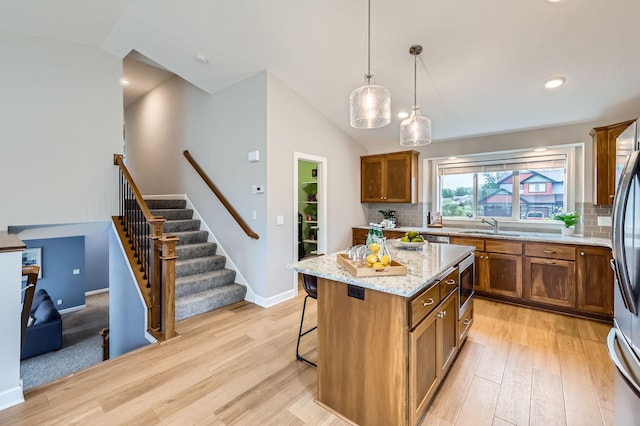 15141 Partridge St NW, Andover, MN 55304 - kitchen with brown cabinetry, light wood finished floors, tasteful backsplash, vaulted ceiling, and recessed lighting