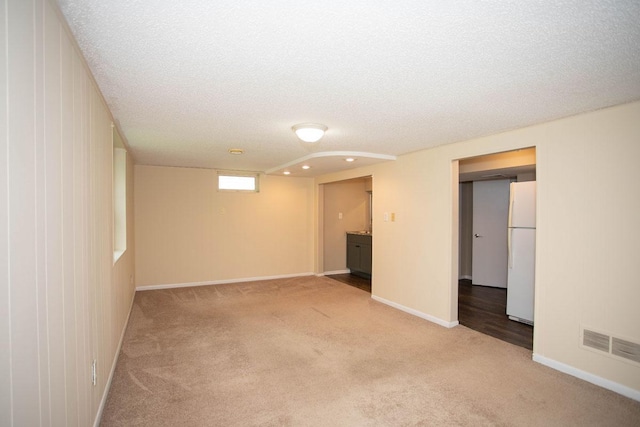 29930 Nathan Ct, Lindstrom, MN 55045 - below grade area with freestanding refrigerator, light carpet, a textured ceiling, and recessed lighting
