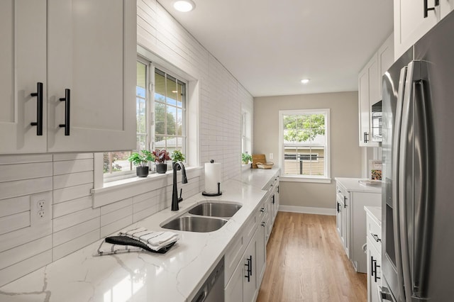 5644 Upton Ave S, Minneapolis, MN 55410 - kitchen with stainless steel appliances, white cabinets, light wood-type flooring, decorative backsplash, and recessed lighting