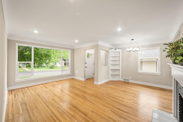 5644 Upton Ave S, Minneapolis, MN 55410 - unfurnished living room featuring light wood-type flooring, a fireplace with flush hearth, a chandelier, and recessed lighting