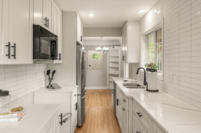 5644 Upton Ave S, Minneapolis, MN 55410 - kitchen with appliances with stainless steel finishes, white cabinets, light stone counters, light wood finished floors, and recessed lighting