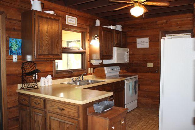47393 209th Pl, Mcgregor, MN 55760 - kitchen featuring white appliances, wood walls, a ceiling fan, light countertops, and a peninsula