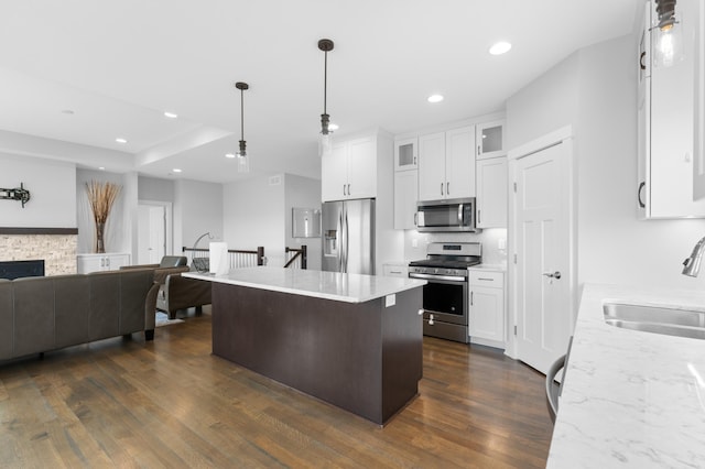 837 Towne Dr NE, Byron, MN 55920 - kitchen with stainless steel appliances, dark wood-style flooring, glass insert cabinets, open floor plan, and white cabinetry
