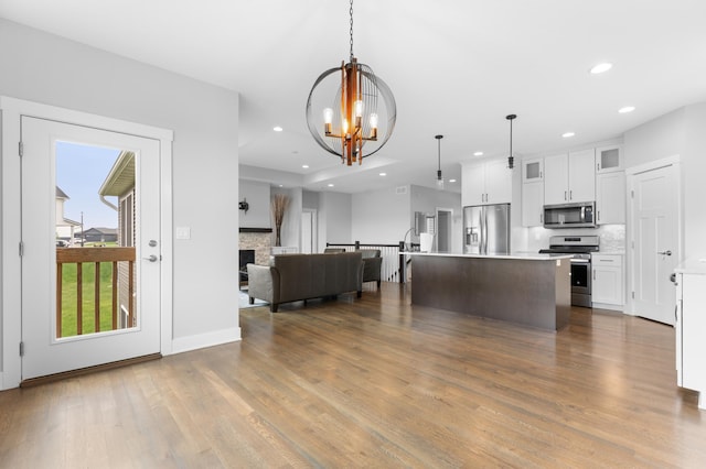 837 Towne Dr NE, Byron, MN 55920 - kitchen featuring stainless steel appliances, open floor plan, wood finished floors, backsplash, and glass insert cabinets