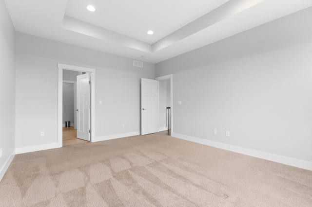 837 Towne Dr NE, Byron, MN 55920 - unfurnished bedroom with light colored carpet, recessed lighting, a tray ceiling, and a spacious closet