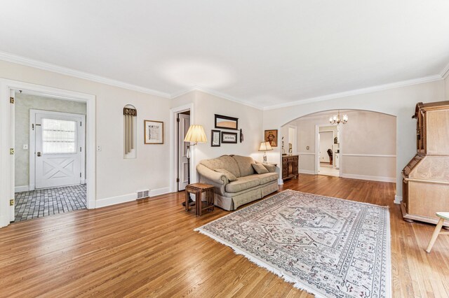 3703 Beard Ave N, Robbinsdale, MN 55422 - living area featuring arched walkways, light wood-type flooring, crown molding, and a chandelier