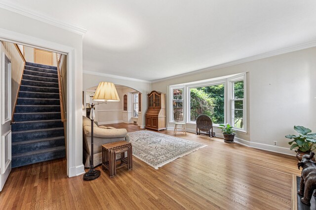 3703 Beard Ave N, Robbinsdale, MN 55422 - living area featuring arched walkways, stairway, wood finished floors, and crown molding