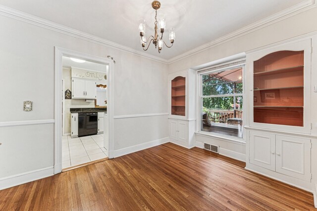 3703 Beard Ave N, Robbinsdale, MN 55422 - unfurnished dining area with a chandelier, light wood-style floors, and crown molding