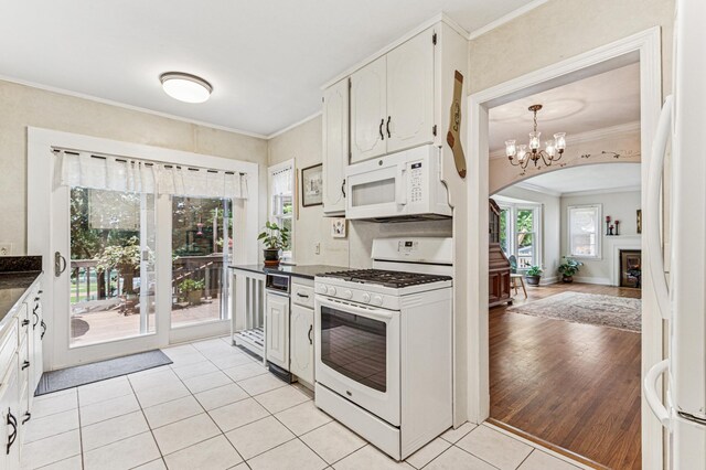 3703 Beard Ave N, Robbinsdale, MN 55422 - kitchen featuring white appliances, dark countertops, light tile patterned floors, ornamental molding, and arched walkways