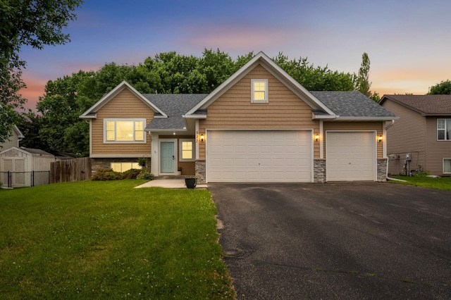 527 1st Ave NE, Lonsdale, MN 55046 - view of front of home featuring stone siding, a garage, asphalt driveway, and roof with shingles