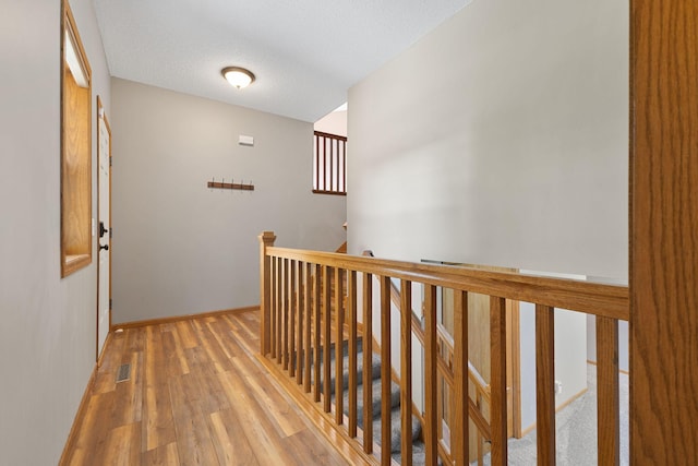 527 1st Ave NE, Lonsdale, MN 55046 - hall with an upstairs landing, light wood finished floors, and a textured ceiling