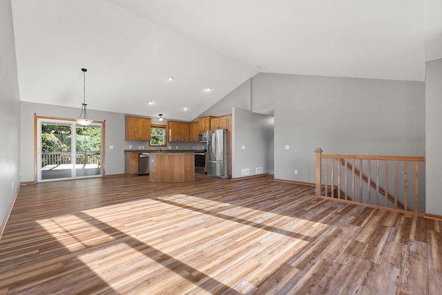 527 1st Ave NE, Lonsdale, MN 55046 - kitchen with stainless steel appliances, open floor plan, wood finished floors, a center island, and high vaulted ceiling