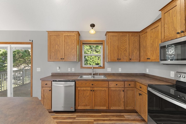 527 1st Ave NE, Lonsdale, MN 55046 - kitchen with stainless steel appliances, dark countertops, wood finished floors, and brown cabinetry