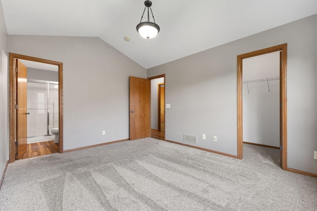 527 1st Ave NE, Lonsdale, MN 55046 - unfurnished bedroom featuring carpet floors, lofted ceiling, a spacious closet, a closet, and ensuite bathroom