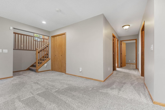 527 1st Ave NE, Lonsdale, MN 55046 - carpeted empty room with stairway and a textured ceiling