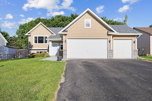 527 1st Ave NE, Lonsdale, MN 55046 - view of front facade with stone siding, driveway, a garage, and a shingled roof