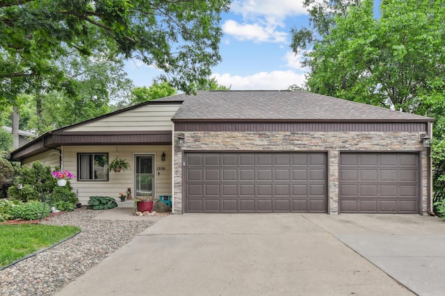1398 Summit Cir W, Saint Paul, MN 55118 - view of front of home featuring an attached garage, concrete driveway, stone siding, and roof with shingles