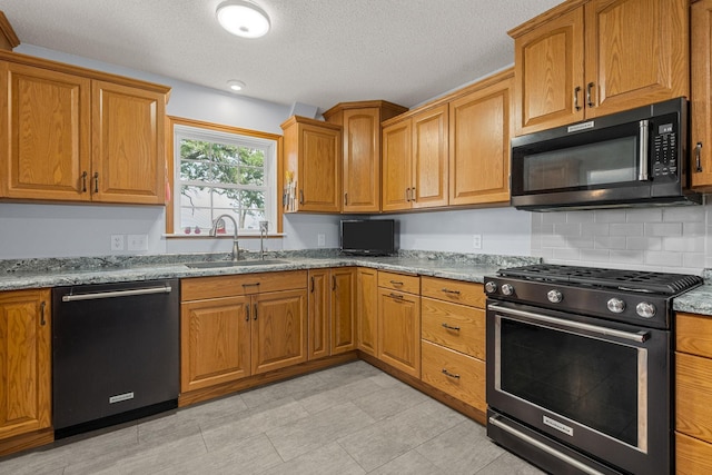 4193 Austin Rd, Owatonna, MN 55060 - kitchen with range with gas cooktop, dishwashing machine, black microwave, light stone countertops, and brown cabinetry
