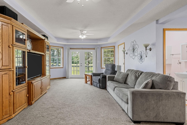 4193 Austin Rd, Owatonna, MN 55060 - living room with ceiling fan, light carpet, a textured ceiling, french doors, and a raised ceiling