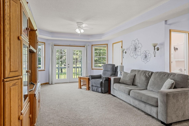 4193 Austin Rd, Owatonna, MN 55060 - carpeted living area featuring a ceiling fan, french doors, a raised ceiling, and a textured ceiling