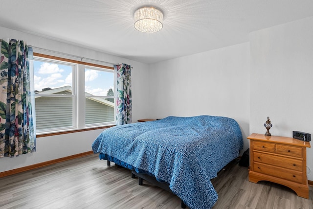 4193 Austin Rd, Owatonna, MN 55060 - bedroom featuring wood finished floors and a chandelier