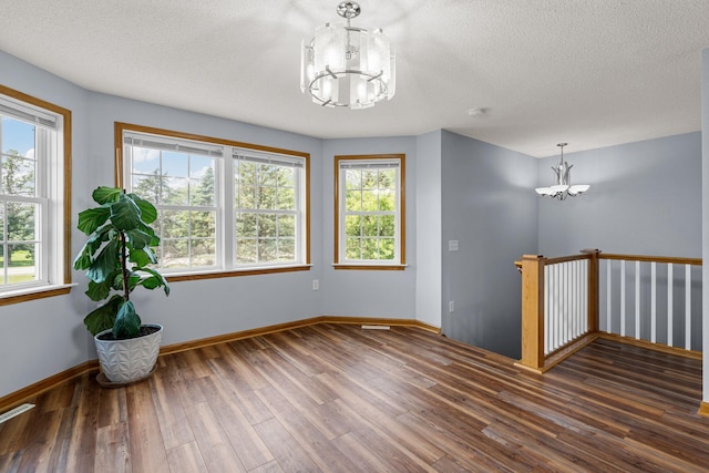 4193 Austin Rd, Owatonna, MN 55060 - empty room featuring a chandelier, wood finished floors, and a textured ceiling