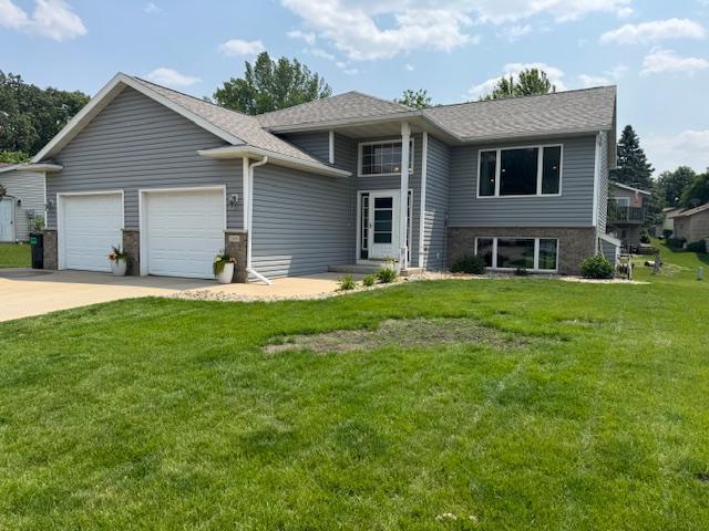 2050 23rd Ln SE, Rochester, MN 55904 - view of front facade with a garage, concrete driveway, a front yard, and stone siding