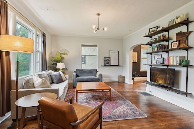 4210 Blaisdell Ave, Minneapolis, MN 55409 - living area featuring arched walkways, crown molding, healthy amount of natural light, wood finished floors, and a chandelier