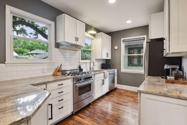 4210 Blaisdell Ave, Minneapolis, MN 55409 - kitchen with stainless steel appliances, under cabinet range hood, white cabinets, dark wood-style flooring, and recessed lighting
