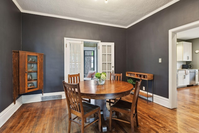 4210 Blaisdell Ave, Minneapolis, MN 55409 - dining area featuring hardwood / wood-style flooring, a textured ceiling, and crown molding