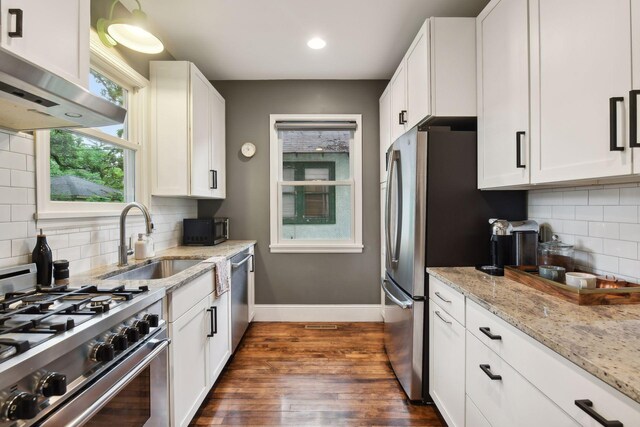 4210 Blaisdell Ave, Minneapolis, MN 55409 - kitchen with appliances with stainless steel finishes, range hood, dark wood-style flooring, white cabinetry, and recessed lighting