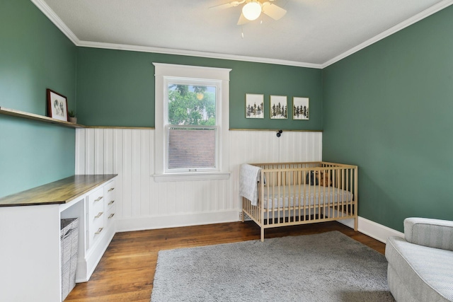 4210 Blaisdell Ave, Minneapolis, MN 55409 - bedroom featuring wood finished floors, wainscoting, ornamental molding, a ceiling fan, and a nursery area