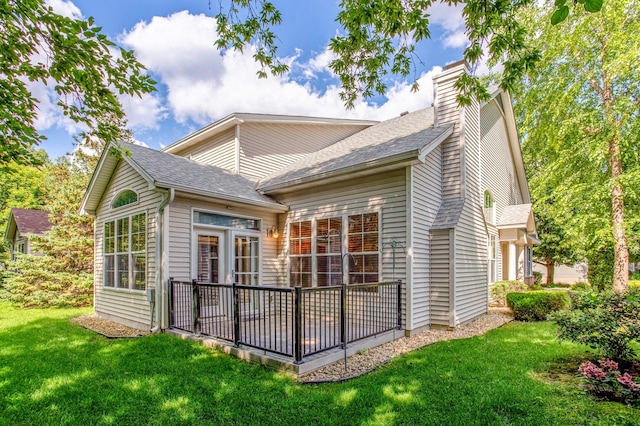 10725 Toledo Ln N, Brooklyn Park, MN 55443 - rear view of house featuring a lawn, a shingled roof, and a chimney