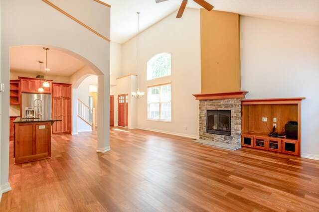 10725 Toledo Ln N, Brooklyn Park, MN 55443 - unfurnished living room featuring high vaulted ceiling, ceiling fan, light wood-style flooring, and arched walkways